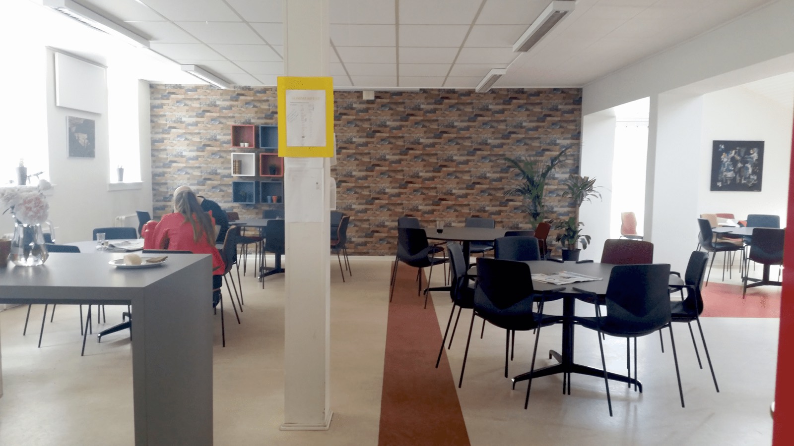 Samme personalerum efter indretningen — lysere, varmere og opdelt i arbejdsplads og pauseområde